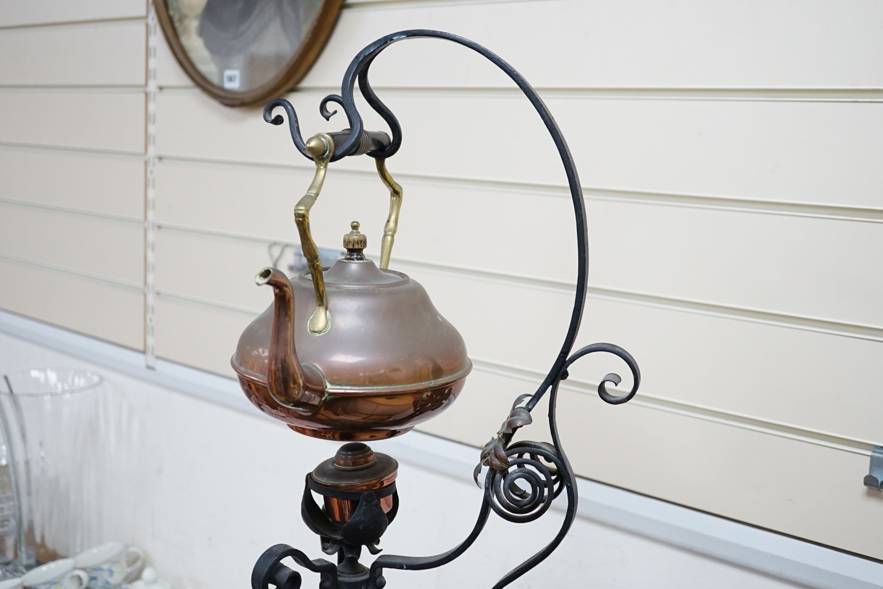 An Arts & Crafts wrought iron and copper burner stand with associated copper kettle 83cm